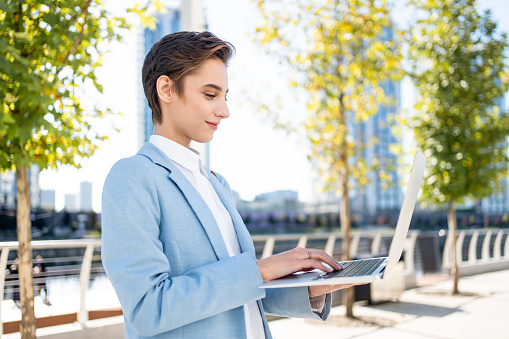 Beautiful young woman with short hair in the city - Pretty caucasian female adult business woman wearing elegant suit going to work in the office