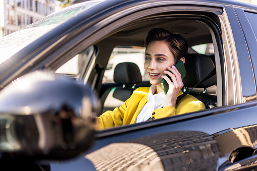 Beautiful young woman with short hair driving car in the city - Pretty caucasian female adult business woman wearing elegant suit going to work in the office