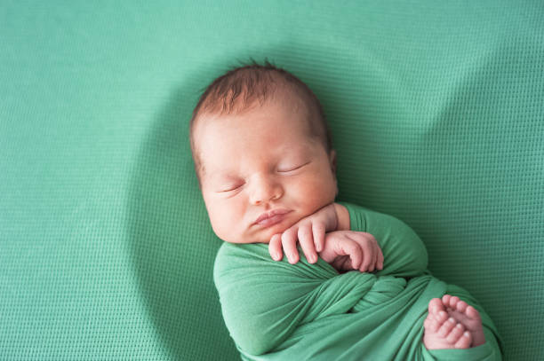 istock Newborn baby in green diaper is sleeping. 1448206873