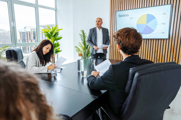 istock Experienced businessman leading business meeting using statistics chart on presentation TV 1448216850
