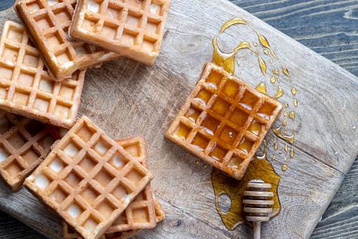 square sweet soft waffles in bee honey , a traditional European dessert of soft waffles in sweet honey