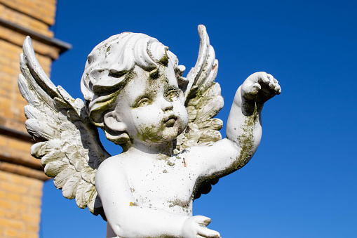 Little angel against blue sky as symbol of guards for child. Copy space.