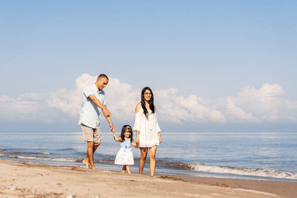 istock Latin american young family walking on the beach. 1448225310