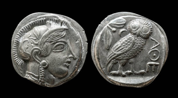 Ancient Greek coin showing goddess Athena and owl Ancient Greek coin showing goddess Athena and owl. Old rare money of Athens, silver tetradrachm isolated on black background, macro. Theme of Greece, valuable coin, civilization, culture and history ancient coins of greece stock pictures, royalty-free photos & images