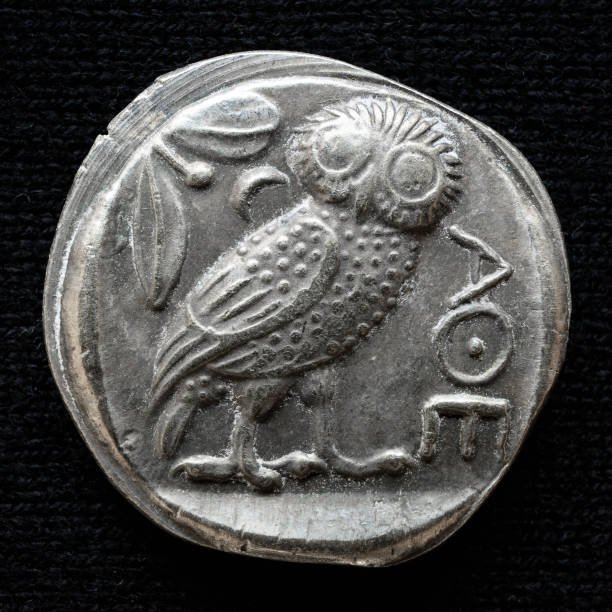 Ancient Greek coin showing owl and inscription Athens Ancient Greek coin showing owl and inscription Athens. Old rare money, silver tetradrachm isolated on dark background, macro. Concept of Greece, valuable coin, past civilization, artifact and history ancient coins of greece stock pictures, royalty-free photos & images