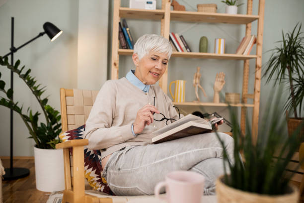 istock Senior woman enjoying reading at home 1448225537