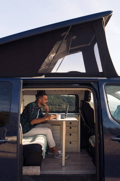 istock man in his camper van working on his laptop 1448225893