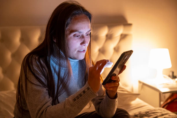 woman in hotel room at night using her phone. - market european culture caucasian stock market imagens e fotografias de stock