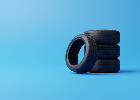 Stack of car tires on a blue background. Concept of changing tires for seasonal, using tires on snow, ice. Replacing tires with summer or winter. 3D render 3D illustration
