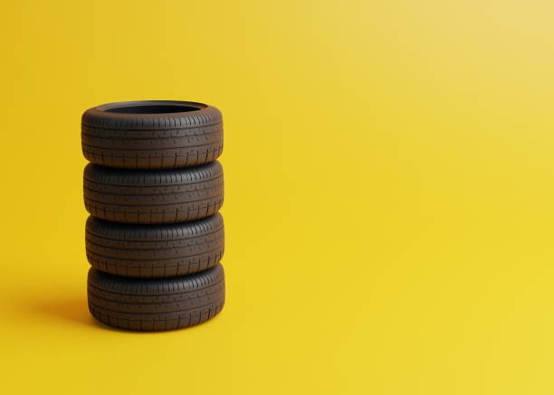 istock Stack of car tires on a yellow background 1448227241