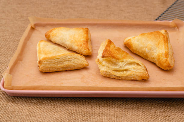 istock Apple turnover close-up on a baking sheet on the table, just from the oven, rustic background 1448230460