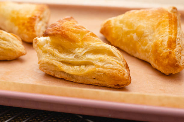 Apple turnover close-up on a baking sheet on the table, just from the oven Apple turnover close-up on a baking sheet on the table, just from the oven apple strudel stock pictures, royalty-free photos & images