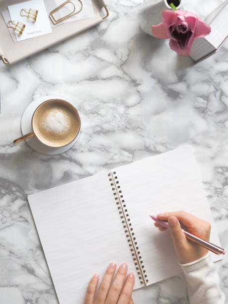 istock Feminine desk in marble and woman writing in notebook 1448233938