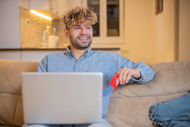 istock Cheerful man doing online shopping 1448234226