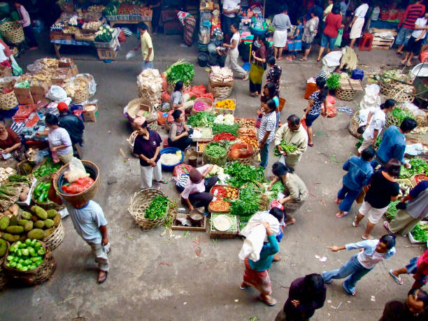 Horizontal high angle photo of Balinese people shopping and selling a variety of food items at the daily fresh food market. Ubud, Bali. 7th October 2007