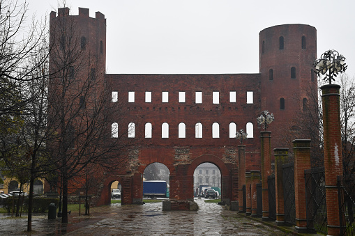 Turin, Italy - December 18, 2019: Porta Palatina (Palatine Gate), an Ancient Roman city gate, on a rainy day.