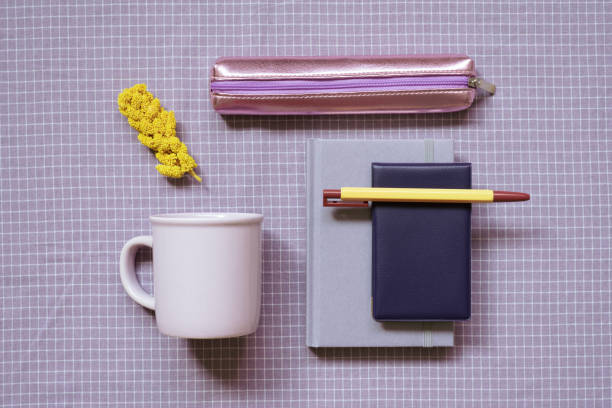 istock Stationery, office supplies. Notebook, pen, mug cup, pencil case on purple check pattern fabric background. flat lay, top view 1448244926