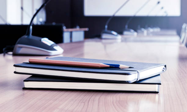 Close up pencil and notebook on table in meeting room Close up pencil and notebook on table in meeting room interview seminar microphone inside of stock pictures, royalty-free photos & images