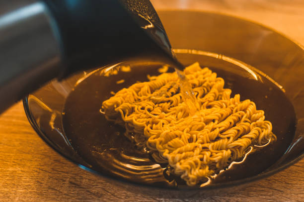 istock Pouring quick-brewed vermicelli with boiled water from the kettle. 1448249380