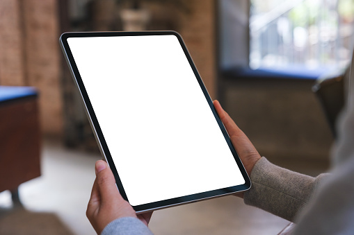 Mockup image of a woman holding digital tablet with blank white desktop screen