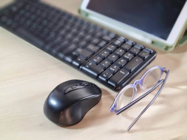istock Tablet, computer keyboard, mouse and glasses on the desk. 1448250995