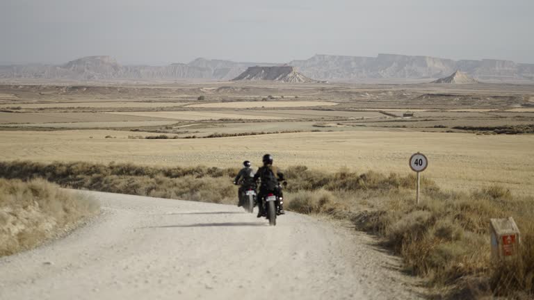 Two adult motorcyclists talking about the road route to follow