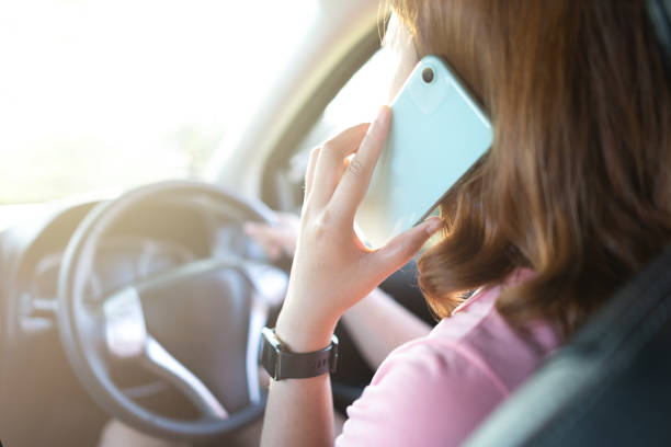 istock woman driving and using mobile phone 1448254672