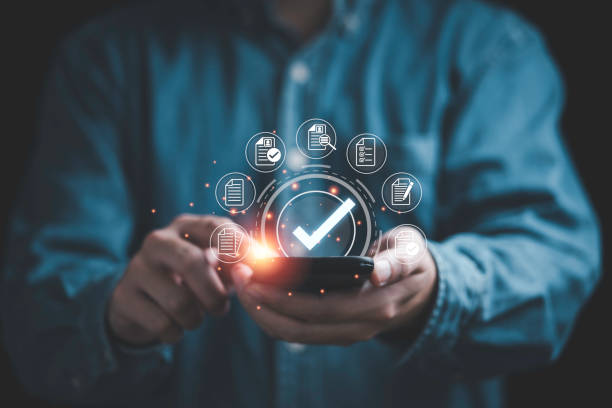istock Businessman using smartphone and  virtual correct sign or tick mark with document icon for approve quality assurance and guarantee concept. 1448255559