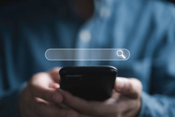 istock Businessman using smartphone with searching bar icon for Search Engine Optimization or SEO concept to find information by internet connection. 1448255567