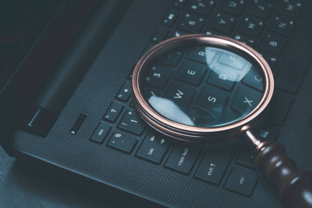 istock Magnifier glass on laptop computer keyboard for Search Engine Optimization or SEO concept to find information by internet connection. 1448255756