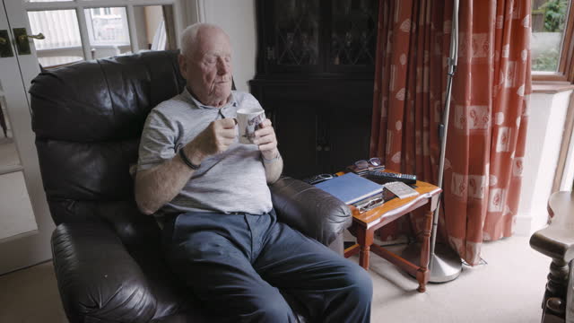 Coffee, relax and senior man thinking of retirement in the living room of his house. Peace, calm and elderly person with idea, tea drink and in a chair in the lounge for stress relief and relaxation