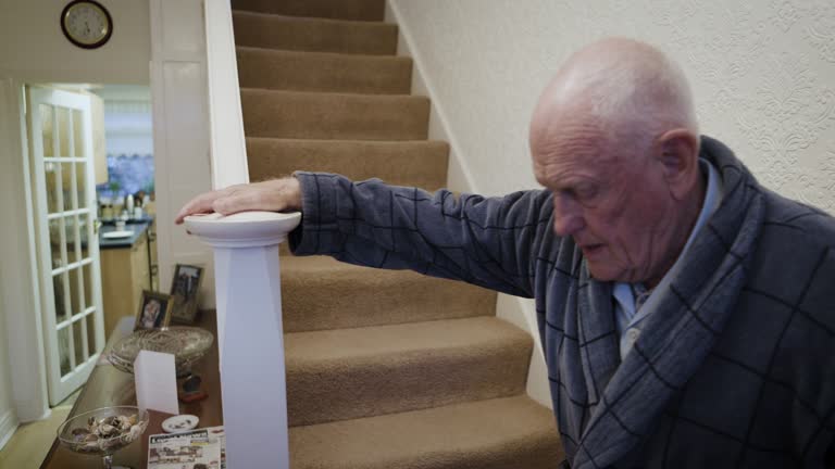 Senior man walking stairs in home with railing support for disability, osteoporosis and elderly help. Old man climbing down steps, staircase and independence in apartment, retirement and pensioner