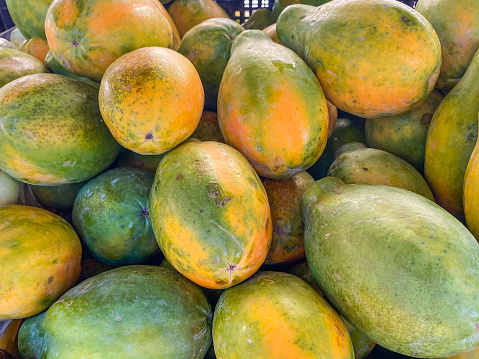 One of the many fruits that can be found in tropical environments. The mangos are on display and ready to be purchased from a market.