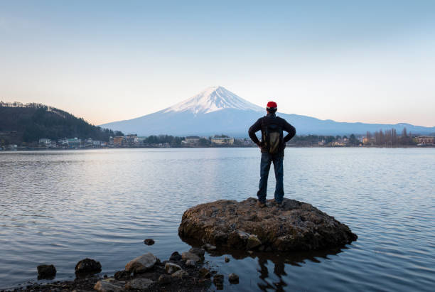 uomo che gode della vista dell'alba sul monte fuji, sponda settentrionale del lago kawaguchiko, giappone. - lago kawaguchi foto e immagini stock