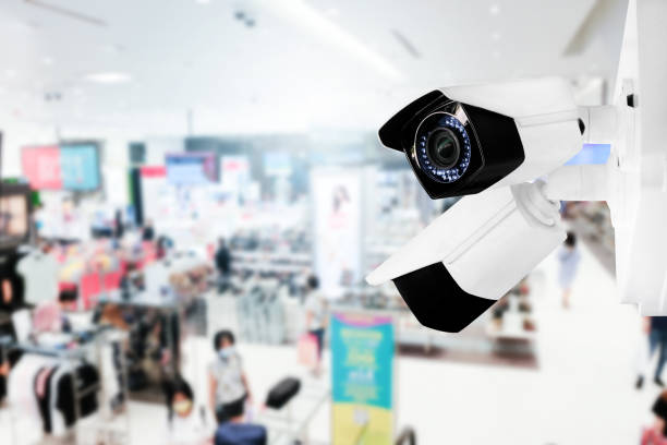 istock Modern public CCTV camera with blur interior shopping mall background. Recording cameras for monitoring all day and night. Concept of surveillance and monitoring with copy space. 1448265407