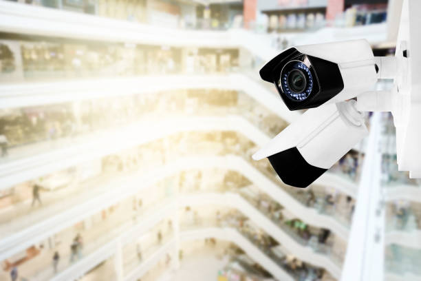 istock Modern public CCTV camera with blur interior shopping mall background. Recording cameras for monitoring all day and night. Concept of surveillance and monitoring with copy space. 1448265409