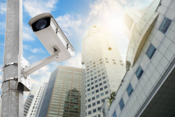 istock Modern public CCTV camera on electric pole with blur building background. Recording cameras for monitoring all day and night. Concept of surveillance and monitoring with copy space. 1448265421