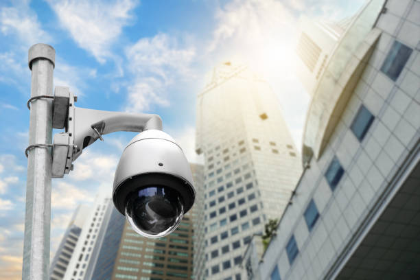 istock Modern public CCTV camera on electric pole with blur building background. Recording cameras for monitoring all day and night. Concept of surveillance and monitoring with copy space. 1448265434