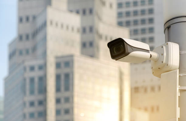 istock Modern public CCTV camera on electric pole with blur building background. Recording cameras for monitoring all day and night. Concept of surveillance and monitoring with copy space. 1448265466