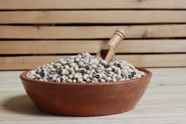 istock Uncooked Black Eyed Peas in Bowl on Wooden Table 1448267664