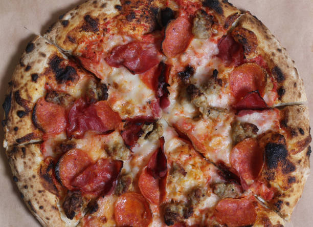 istock Fresh Pizza on Wooden Table at Restaurant Sliced and Ready to Eat 1448267695