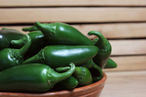 Bowl of Fresh Green Jalapeno Peppers in Rustic Kitchen Bowl of Fresh Green Jalapeno Chili Peppers in Rustic Kitchen Jalapeno harvest stock pictures, royalty-free photos & images
