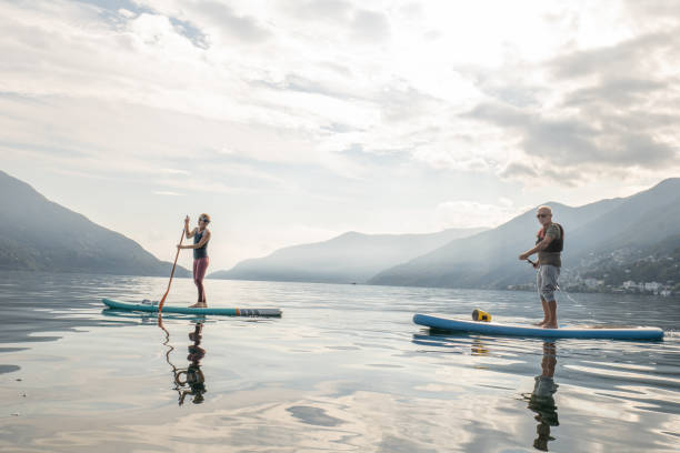 istock Father and daughter on stand up paddle boards at sunrise 1448270587