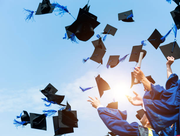 Graduating students hands throwing graduation caps in the air Graduating students hands throwing graduation caps in the air. graduation throwing cap stock pictures, royalty-free photos & images