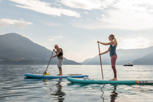 padre e figlia su tavole da stand up paddle all'alba - paddleboard oar women lake foto e immagini stock