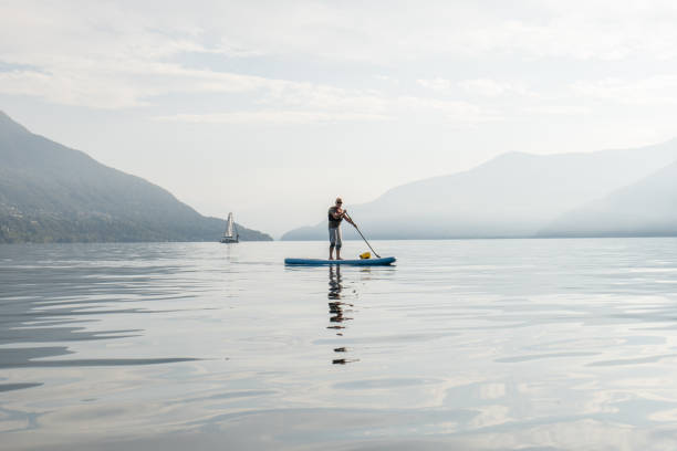 istock Active senior doing stand up board o a lake 1448273890