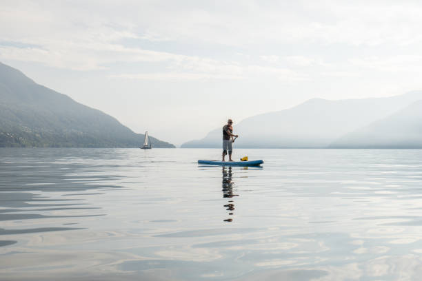 istock Active senior doing stand up board o a lake 1448273929
