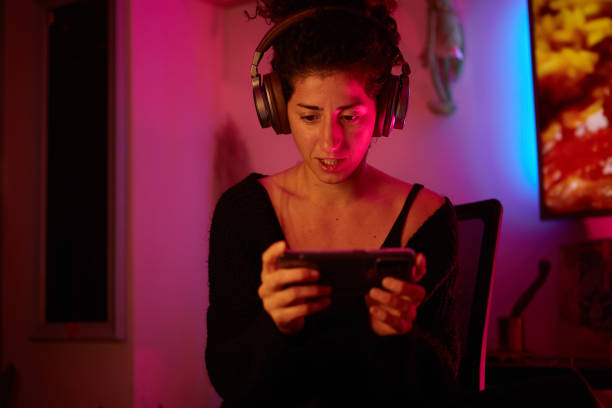 istock A woman playing games on a digital device on the sofa at her home 1448274954