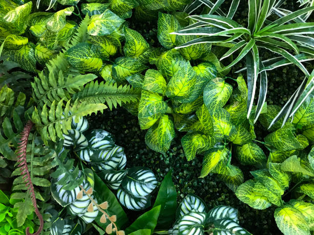 istock Seamless pattern with artificial tropical leaves and flowers on dark background. Tropic rain forest foliage texture. 1448277639