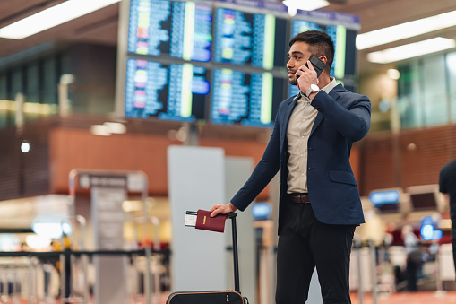 Businessman Looking Away with his phone While Standing At the Airport
